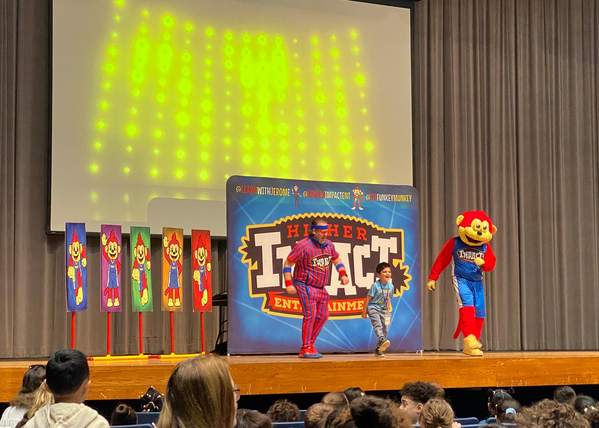 Funkey Munkey Game Show host and mascot leading an interactive on-stage activity with a student<br />
