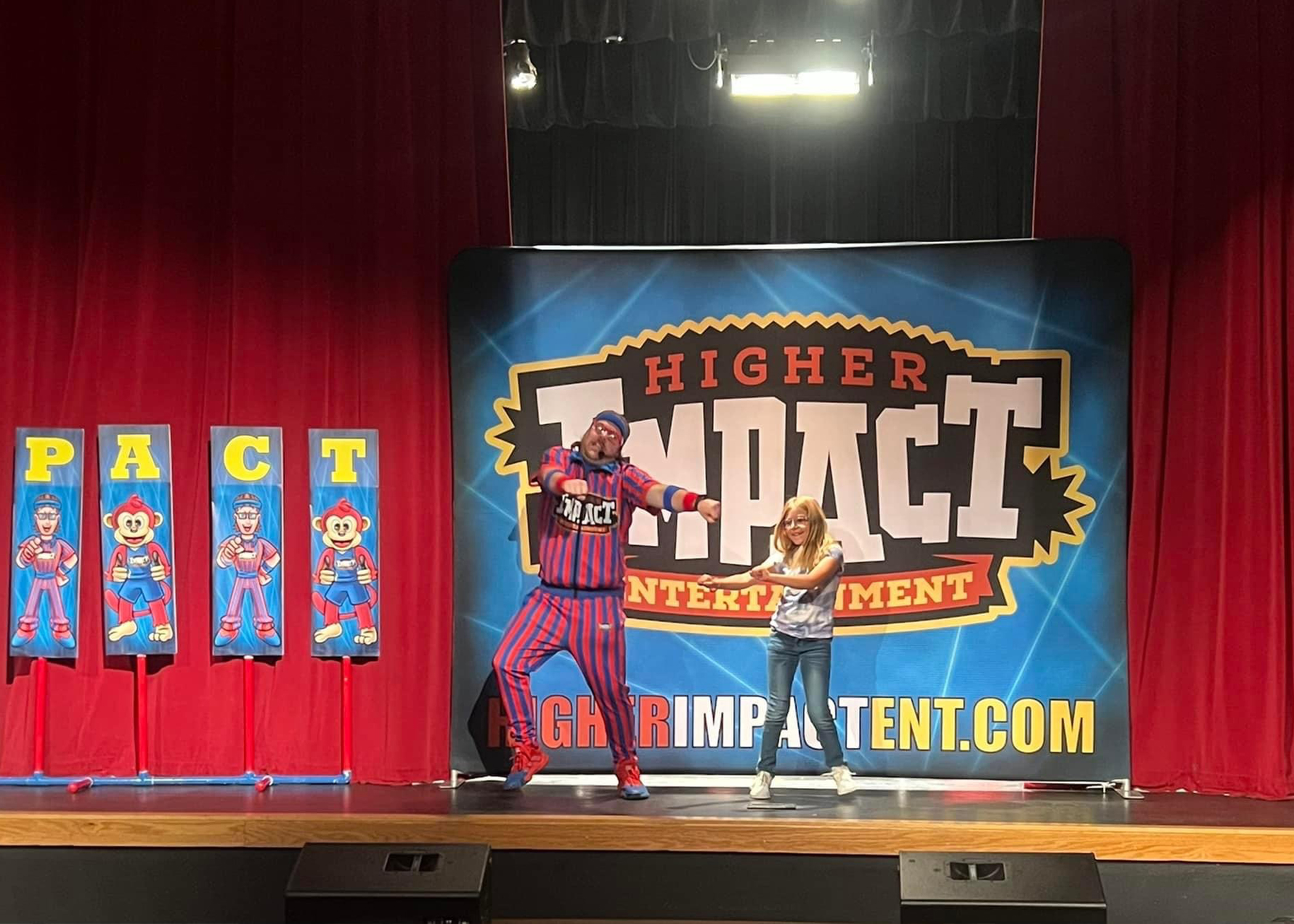 Funkey Munkey Game Show host dancing on stage with a student during a live interactive performance